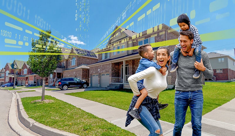 A family of four Playing outside their house which as solar panels on the roof