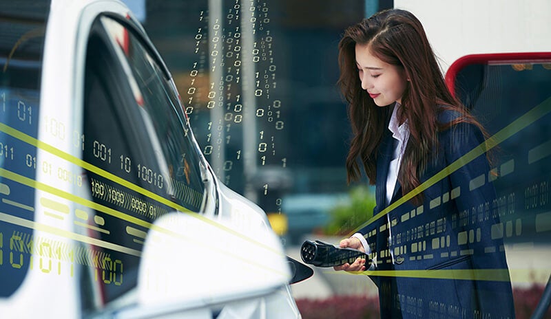 Woman dressed in a business clothes charging an electric car