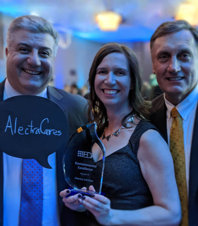 Three alectra employees holding the award and an AlectraCARES sign
