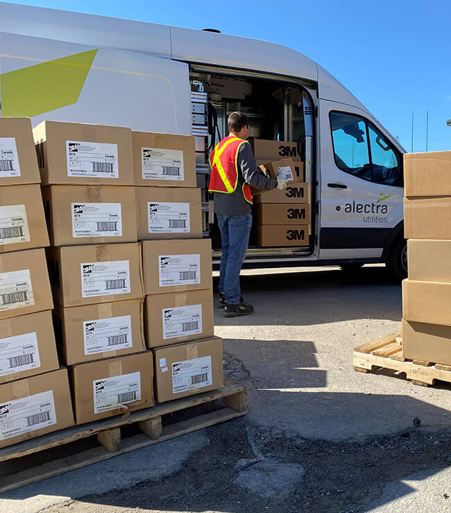 Alectra worker loading an Alectra Truck with boxes of masks